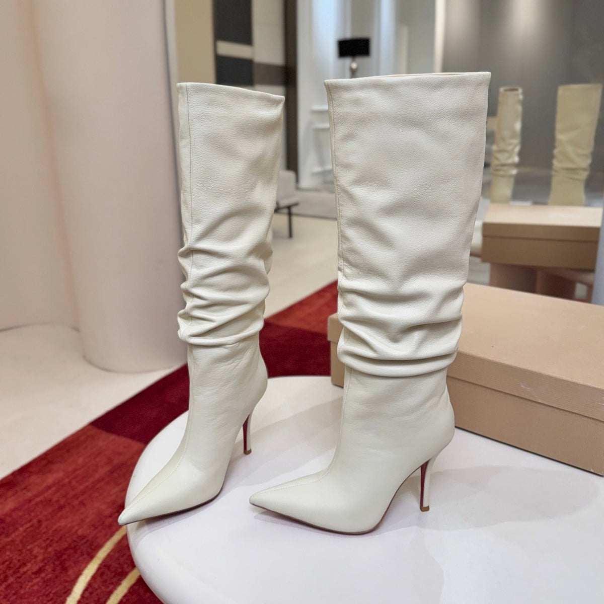 The boot's tapered silhouette creates a refined, modern look. This style features a 100mm stiletto heel.