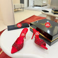 Red openwork high-heeled mules fully encrusted with rhinestones; 10cm heel.