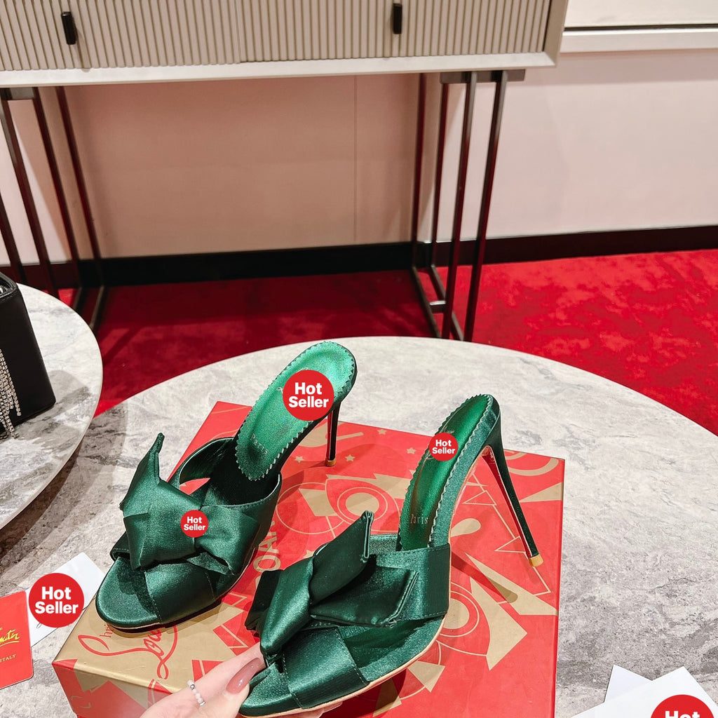 Green high-heeled mules with butterfly-style detail; heel height: 8.5 cm.