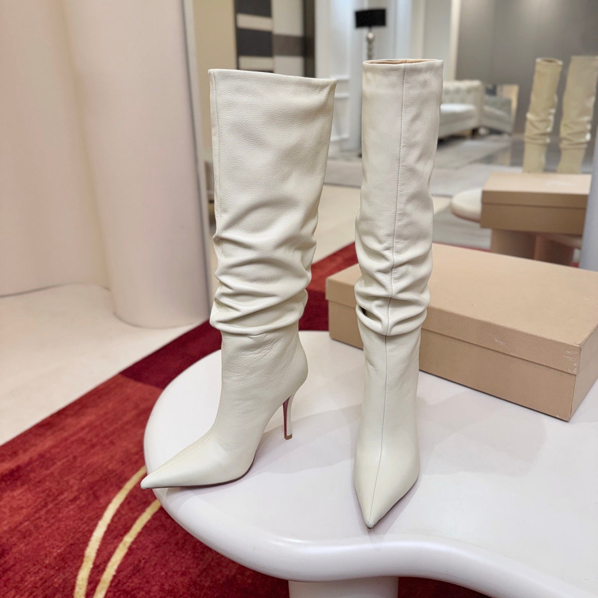 The boot's tapered silhouette creates a refined, modern look. This style features a 100mm stiletto heel.