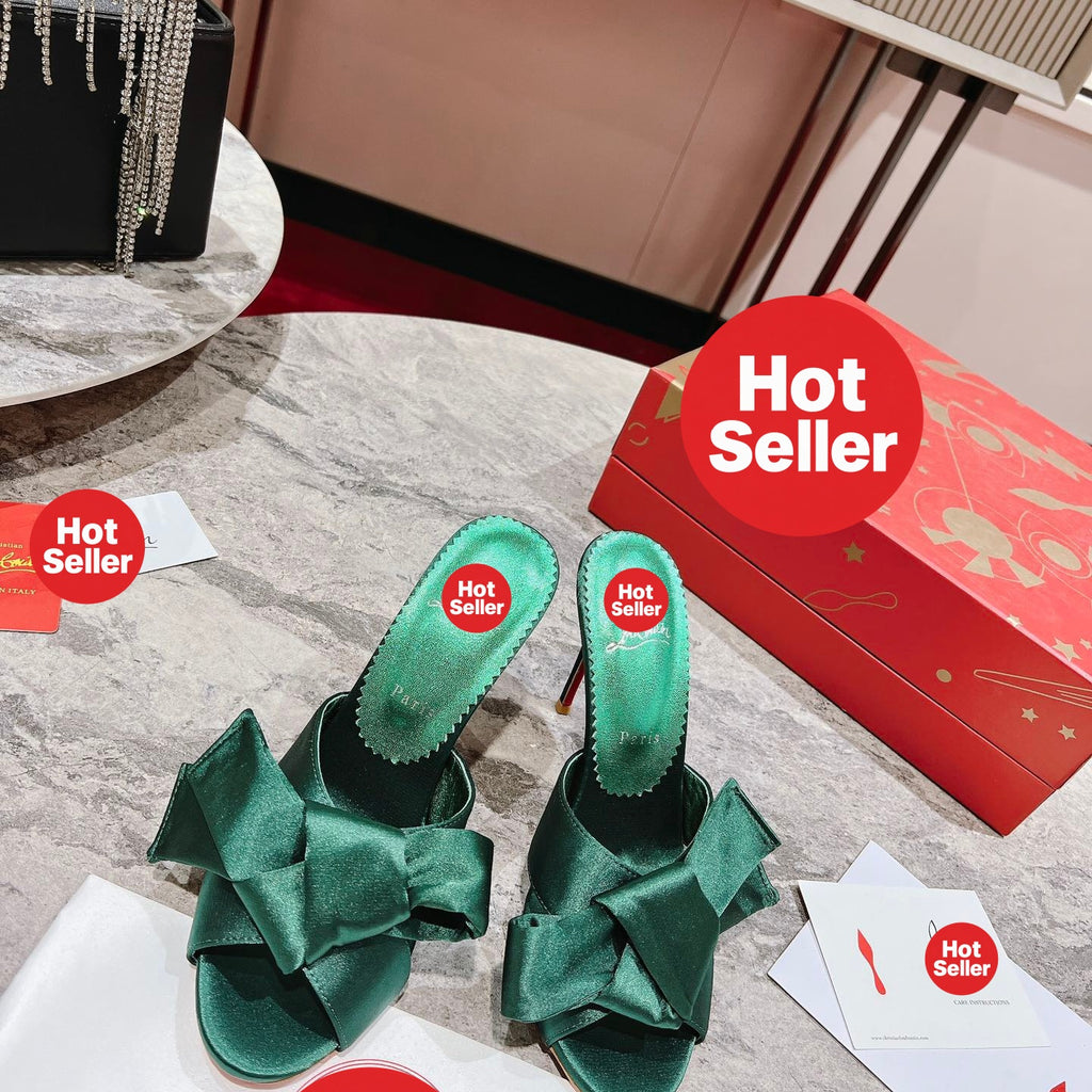 Green high-heeled mules with butterfly-style detail; heel height: 8.5 cm.