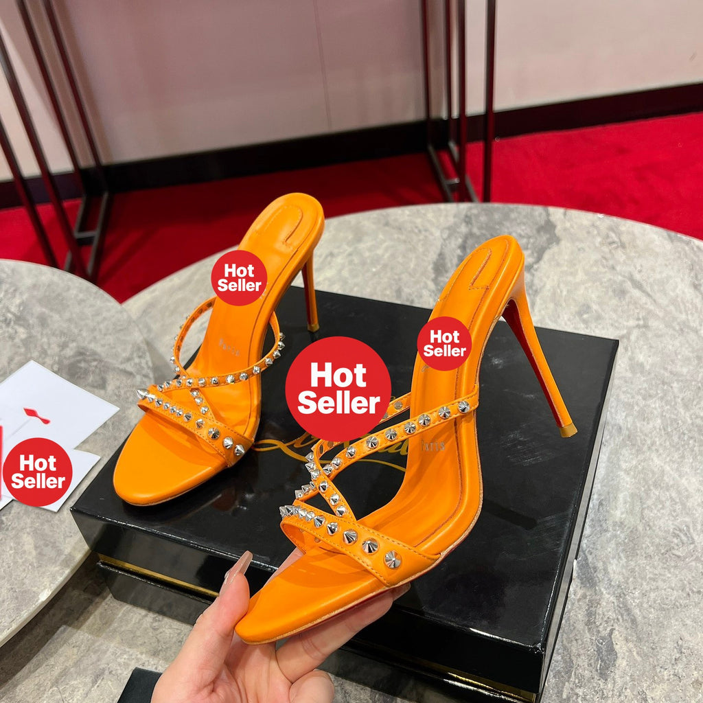 Orange high-heeled mules with studded crisscross straps; 10cm heel.