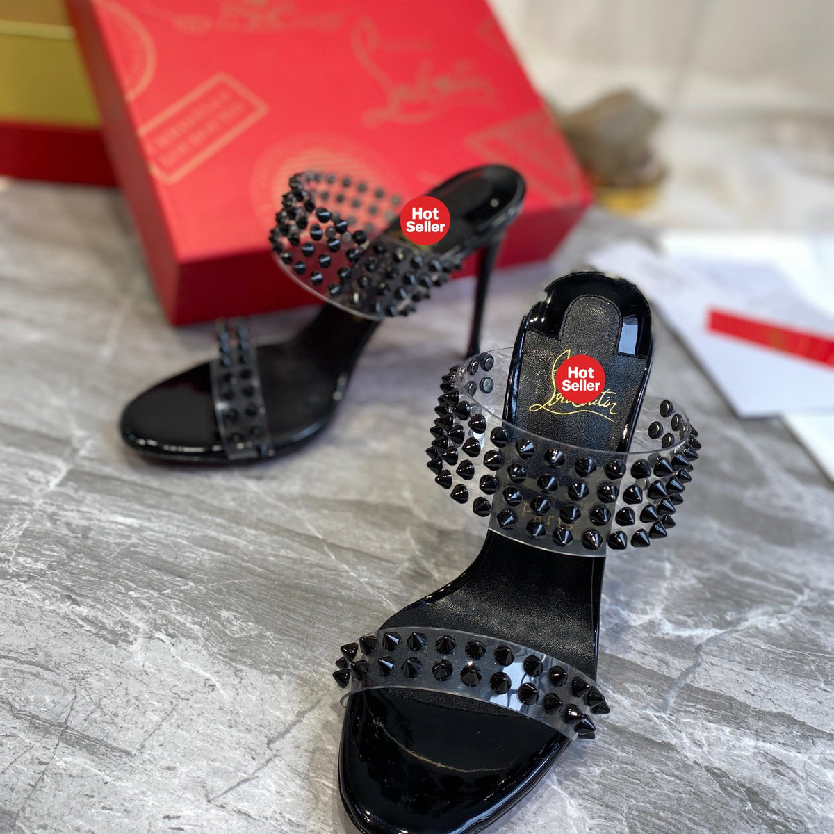 Black high-heeled mules with PVC straps and stud details; 10cm heel.