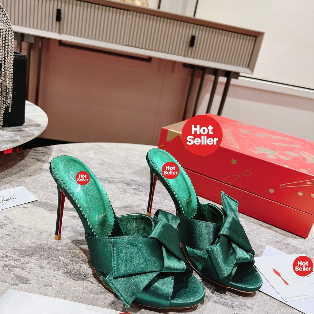 Green high-heeled mules with butterfly-style detail; heel height: 8.5 cm.