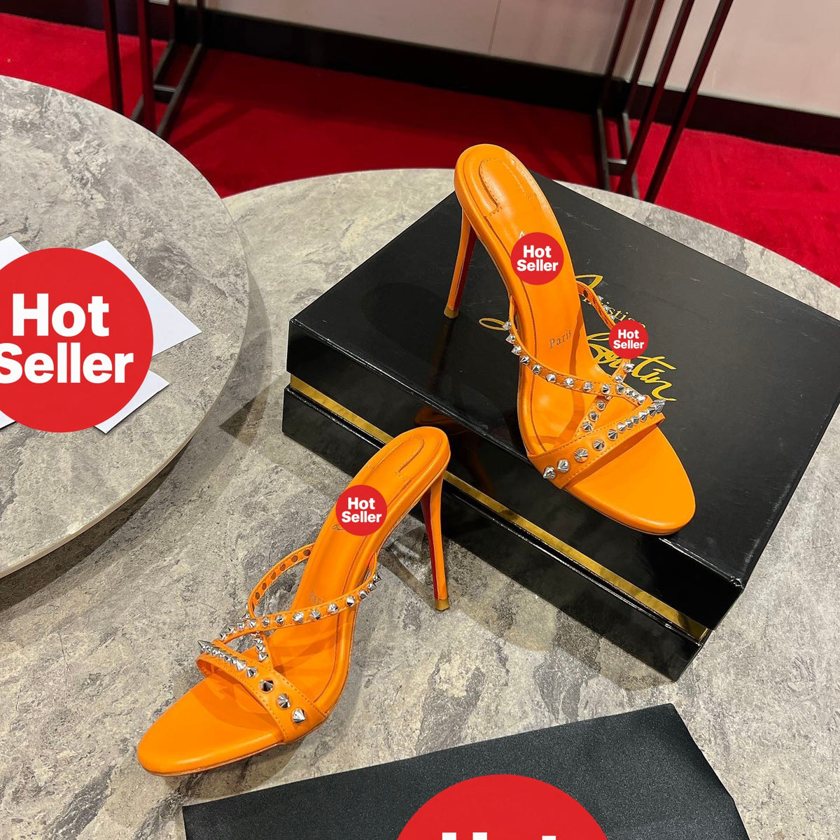 Orange high-heeled mules with studded crisscross straps; 10cm heel.