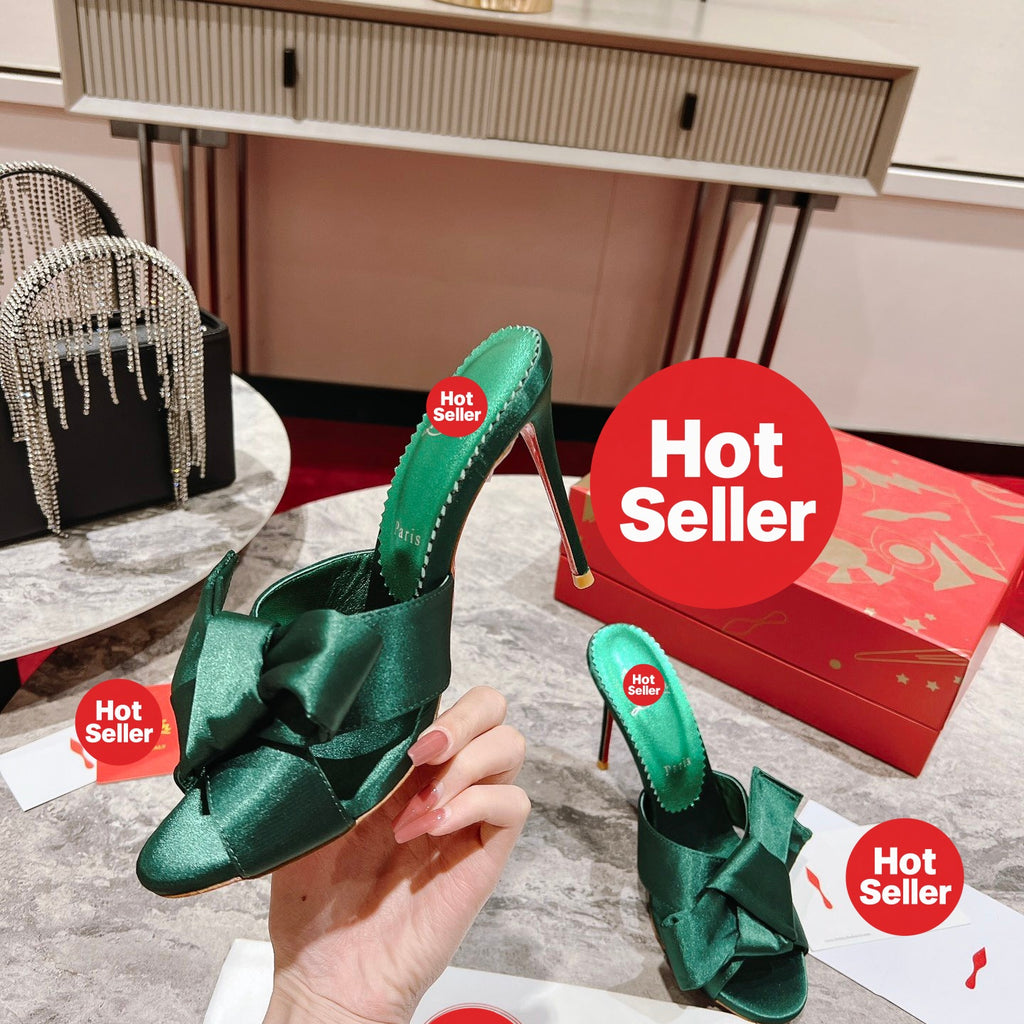 Green high-heeled mules with butterfly-style detail; heel height: 8.5 cm.