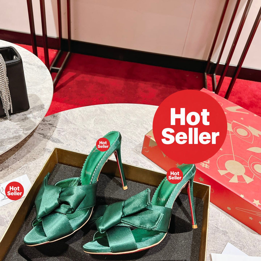 Green high-heeled mules with butterfly-style detail; heel height: 8.5 cm.