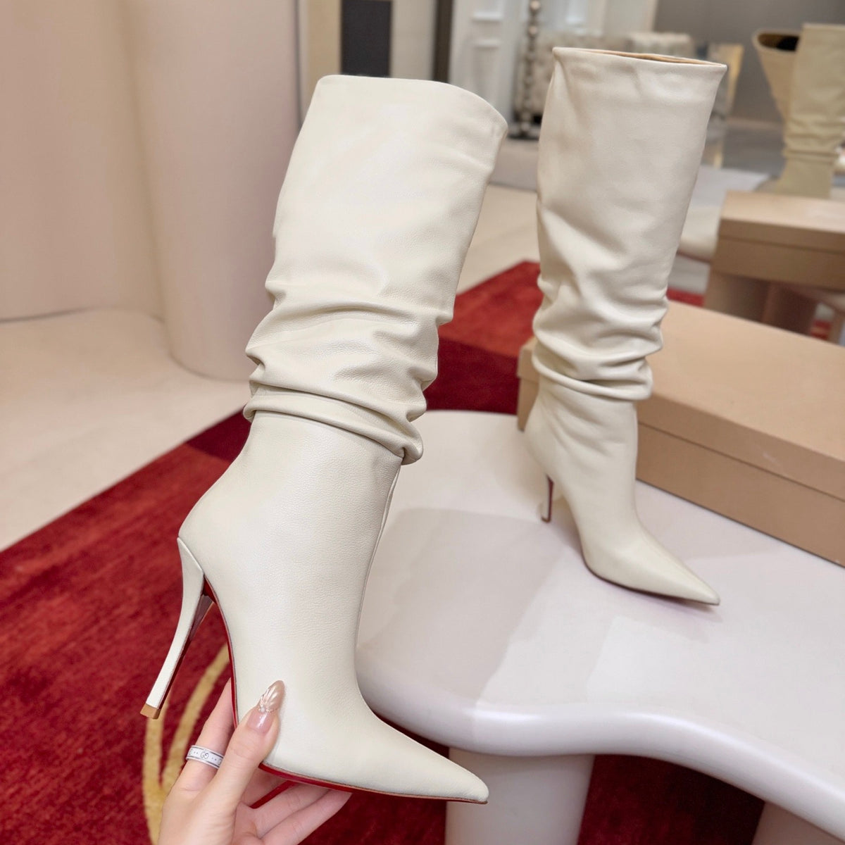 The boot's tapered silhouette creates a refined, modern look. This style features a 100mm stiletto heel.
