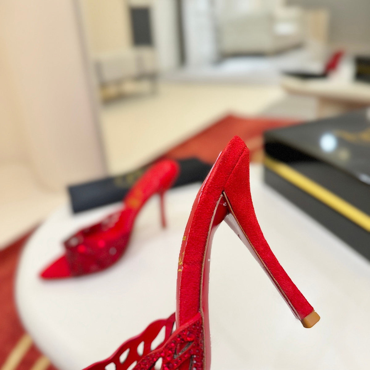 Red openwork high-heeled mules fully encrusted with rhinestones; 10cm heel.