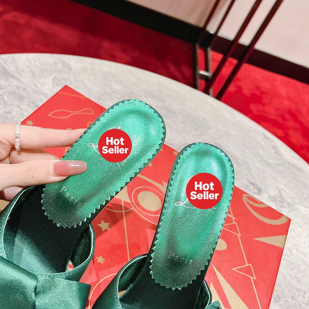 Green high-heeled mules with butterfly-style detail; heel height: 8.5 cm.