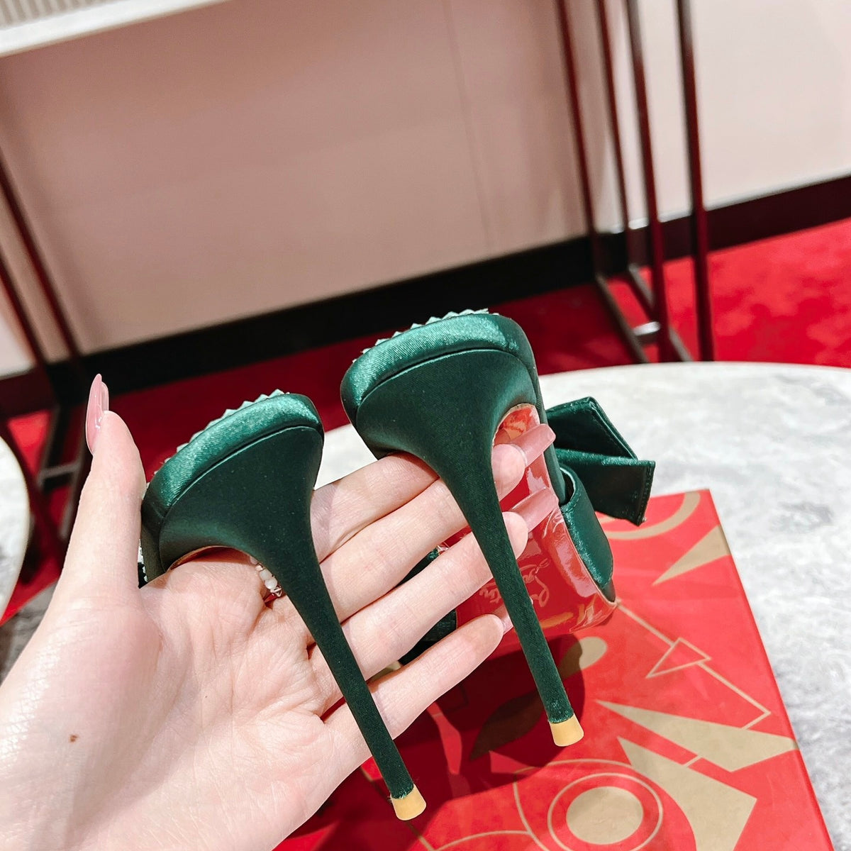 Green high-heeled mules with butterfly-style detail; heel height: 8.5 cm.