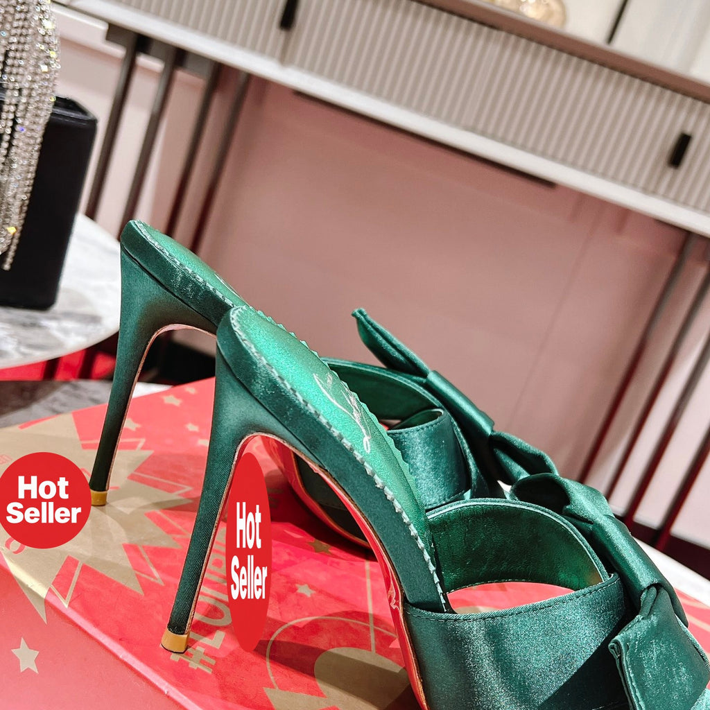 Green high-heeled mules with butterfly-style detail; heel height: 8.5 cm.